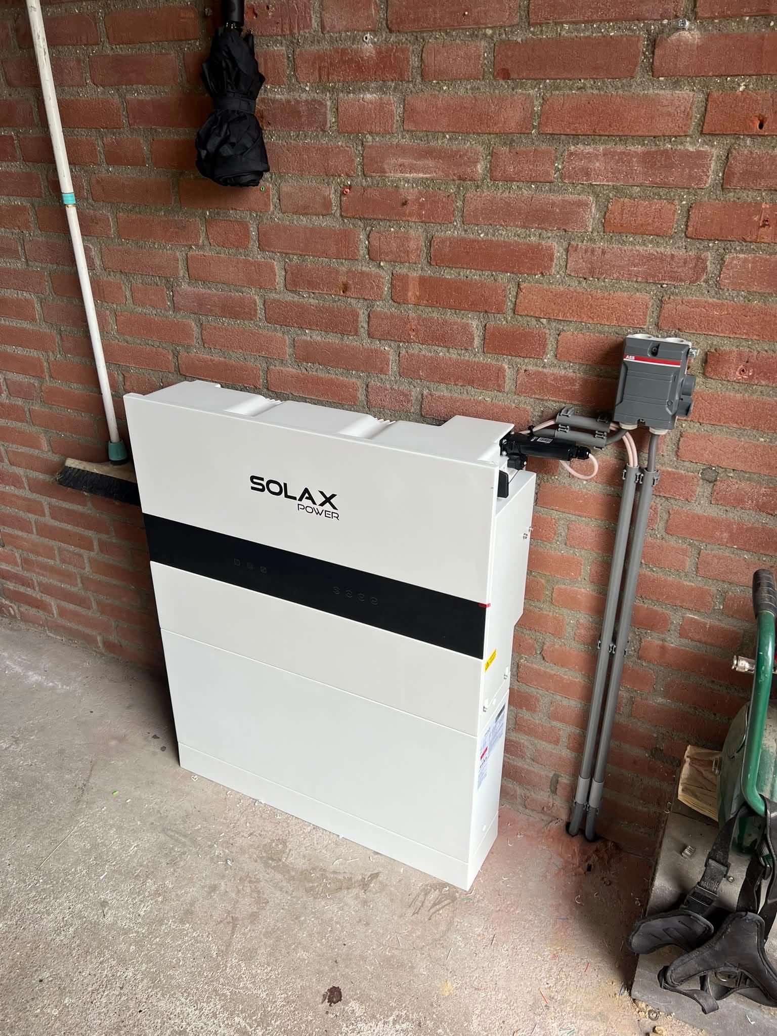 Thuisbatterij met aansluiting aan een bakstenen wand
