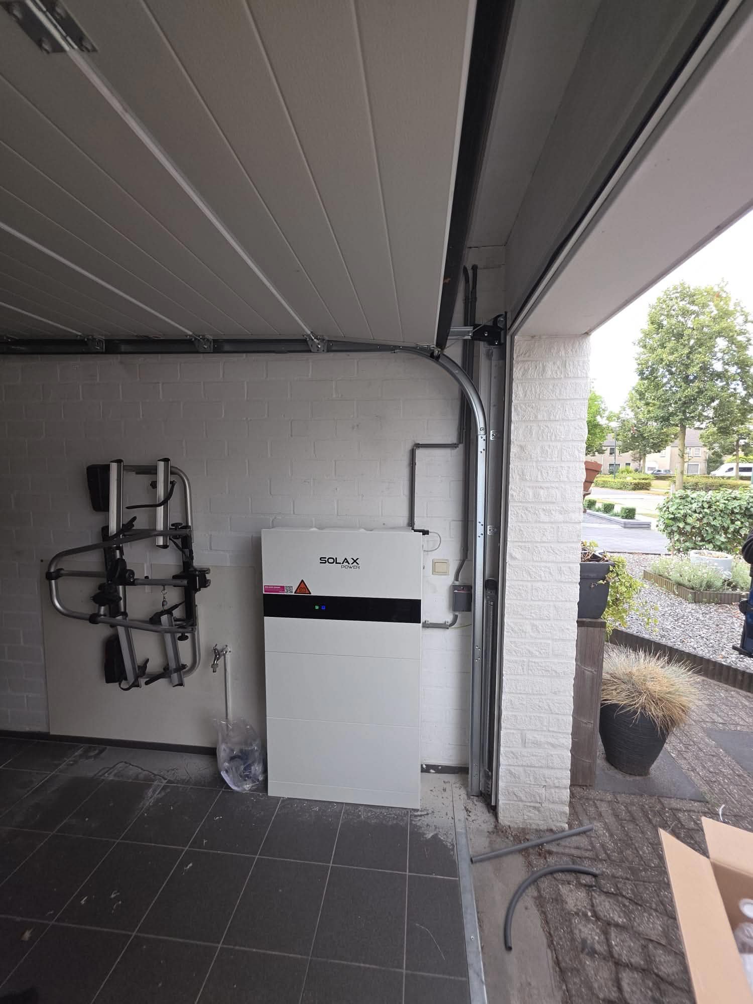 Thuisbatterij tegen een witte wand in een garage